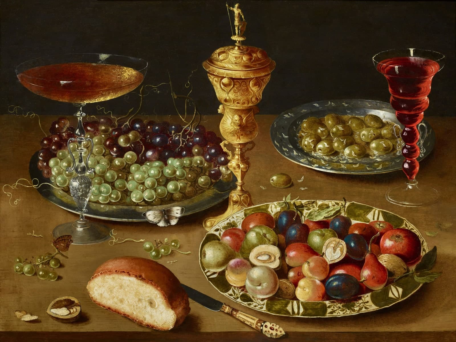 Stilleven met drinkschaal, druiven en olijven