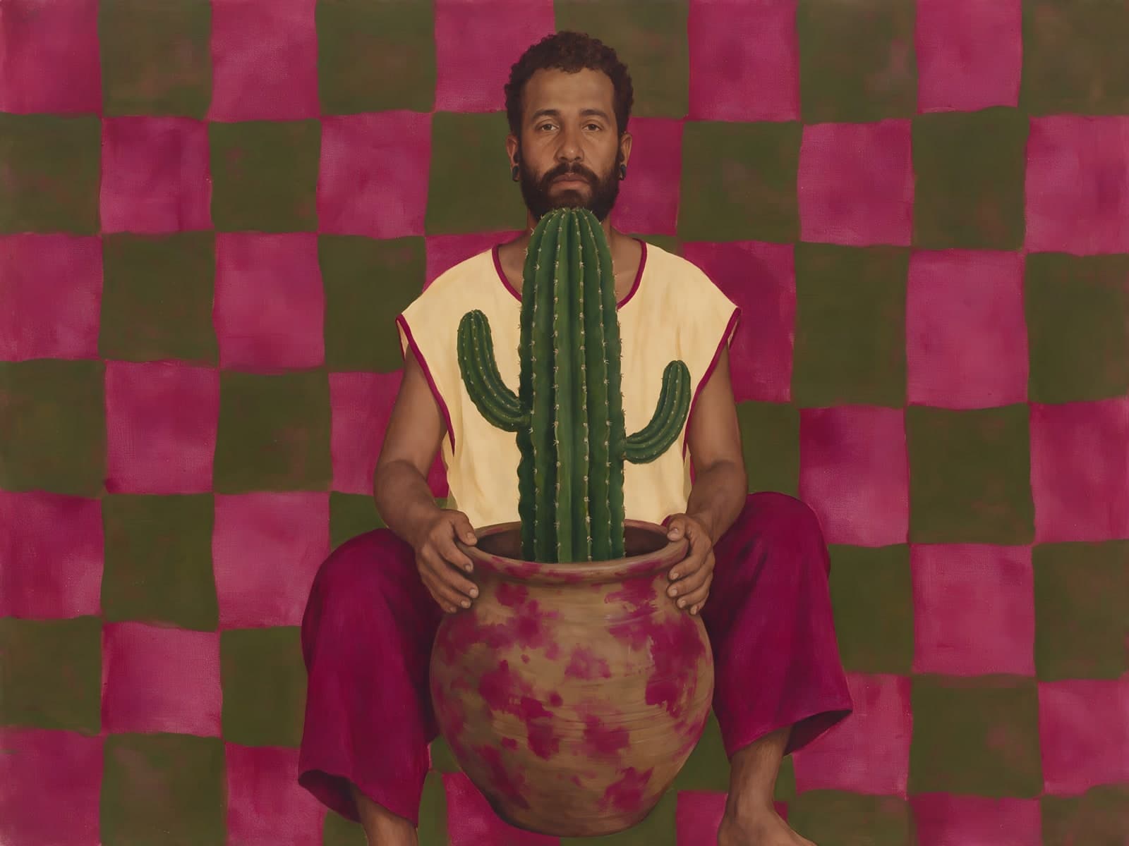 Man met cactus voor een roze ruitpatroon